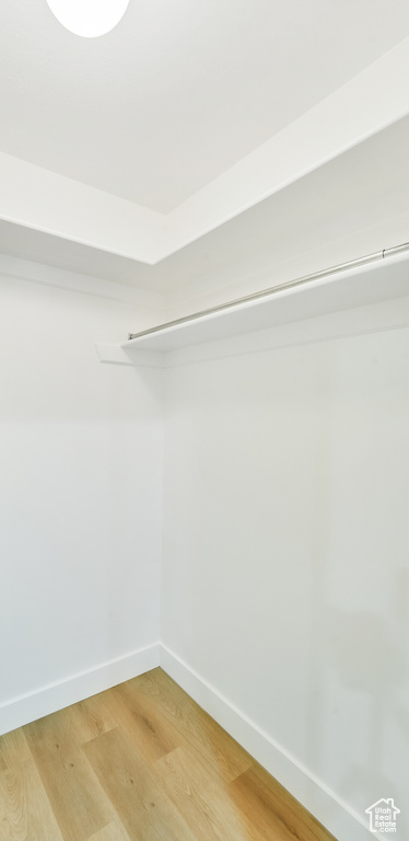 Walk in closet with light wood-style floors