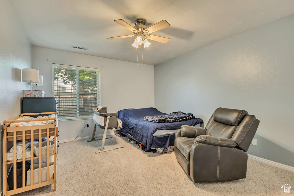 Carpeted bedroom with visible vents, baseboards, and ceiling fan
