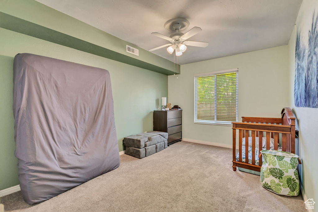 Carpeted bedroom with baseboards, a ceiling fan, and visible vents