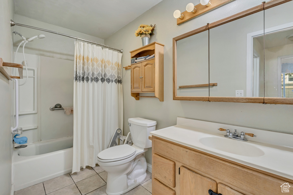 Bathroom with tile patterned flooring, shower / bath combo, toilet, and vanity