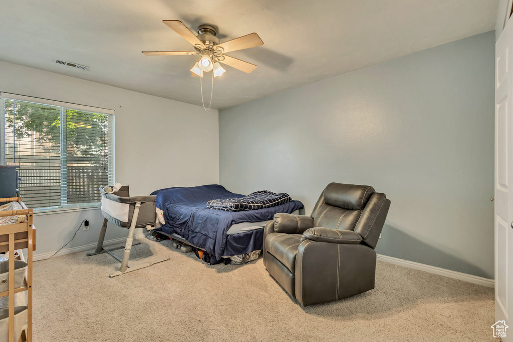 Carpeted bedroom with baseboards, ceiling fan, and visible vents
