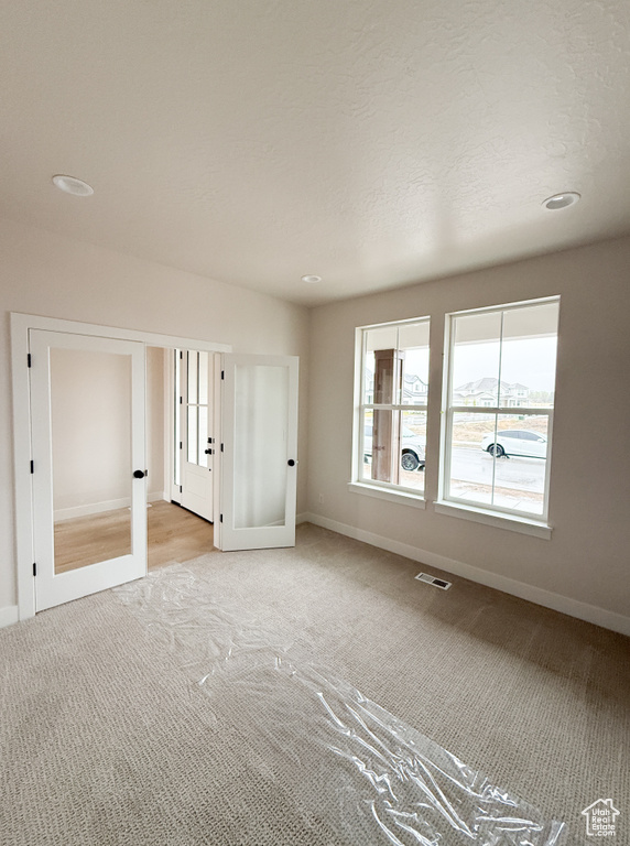 Interior space with recessed lighting, carpet flooring, baseboards, and french doors
