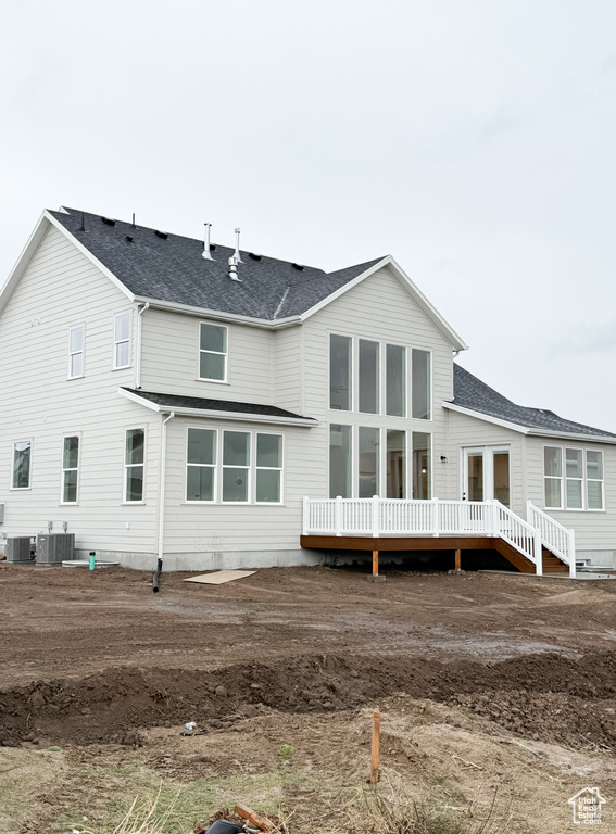 Back of house featuring roof with shingles, central AC, and a deck