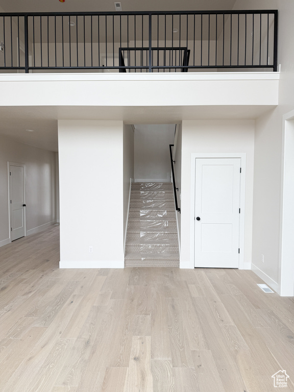 Stairway with wood finished floors, a high ceiling, and baseboards