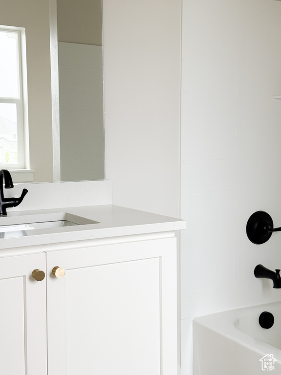 Bathroom with vanity and bathing tub / shower combination