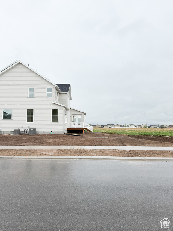 View of side of home featuring central air condition unit and a deck