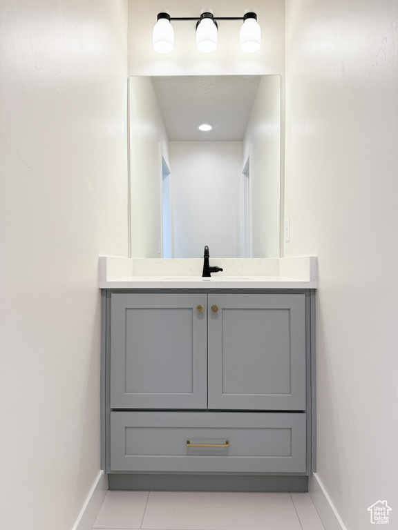 Bathroom with vanity, tile patterned floors, and baseboards