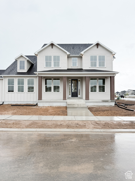 Townhome / multi-family property featuring board and batten siding, roof with shingles, and a porch
