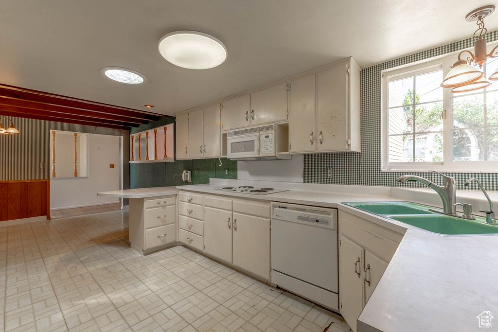 Kitchen featuring a sink, light countertops, backsplash, and white appliances