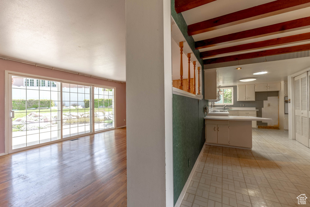 Kitchen with a peninsula, baseboards, open floor plan, light countertops, and a sink