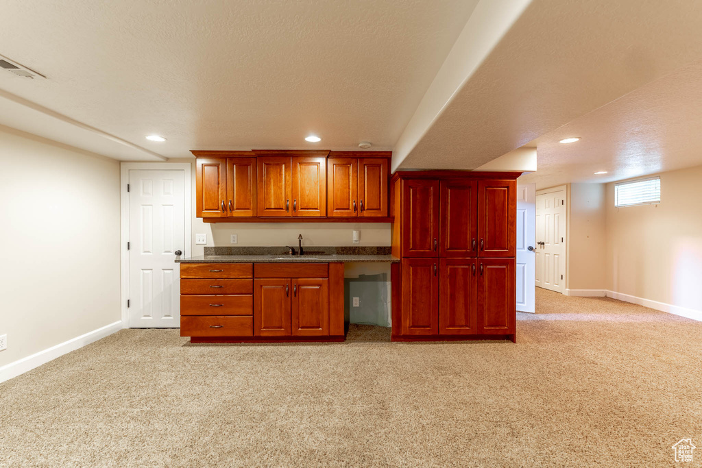 Kitchen with baseboards, light colored carpet, recessed lighting, and visible vents