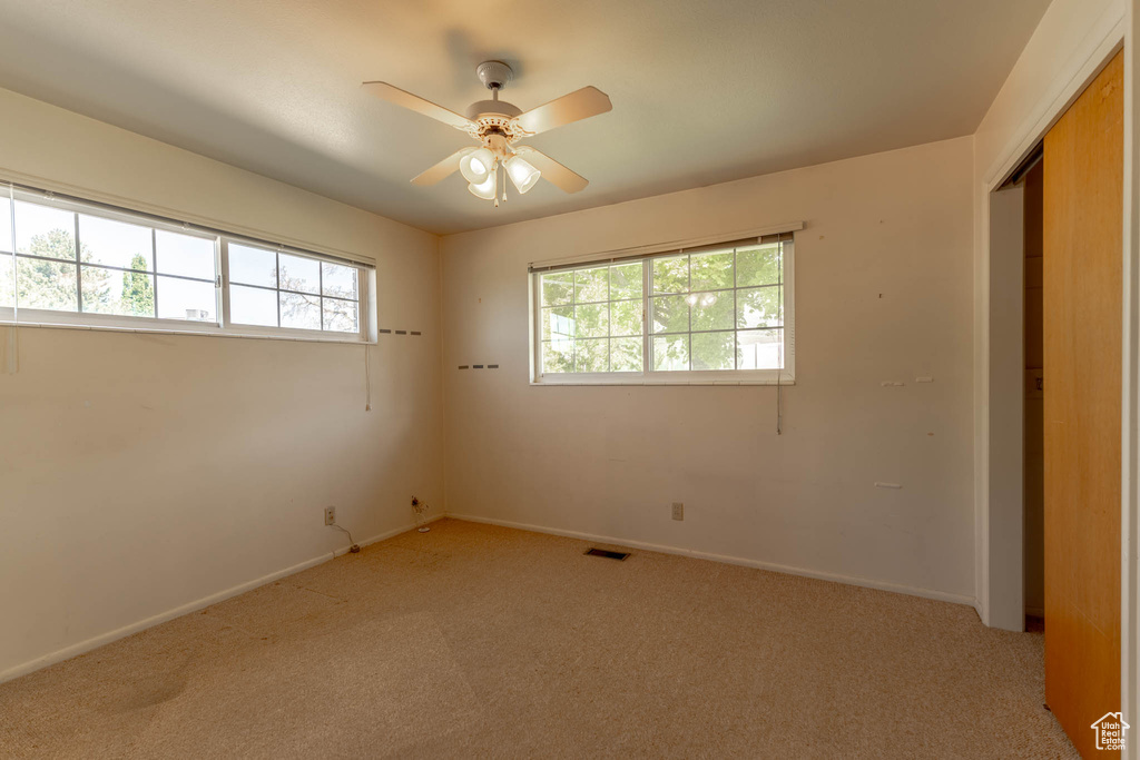 Unfurnished bedroom with baseboards, light carpet, and visible vents