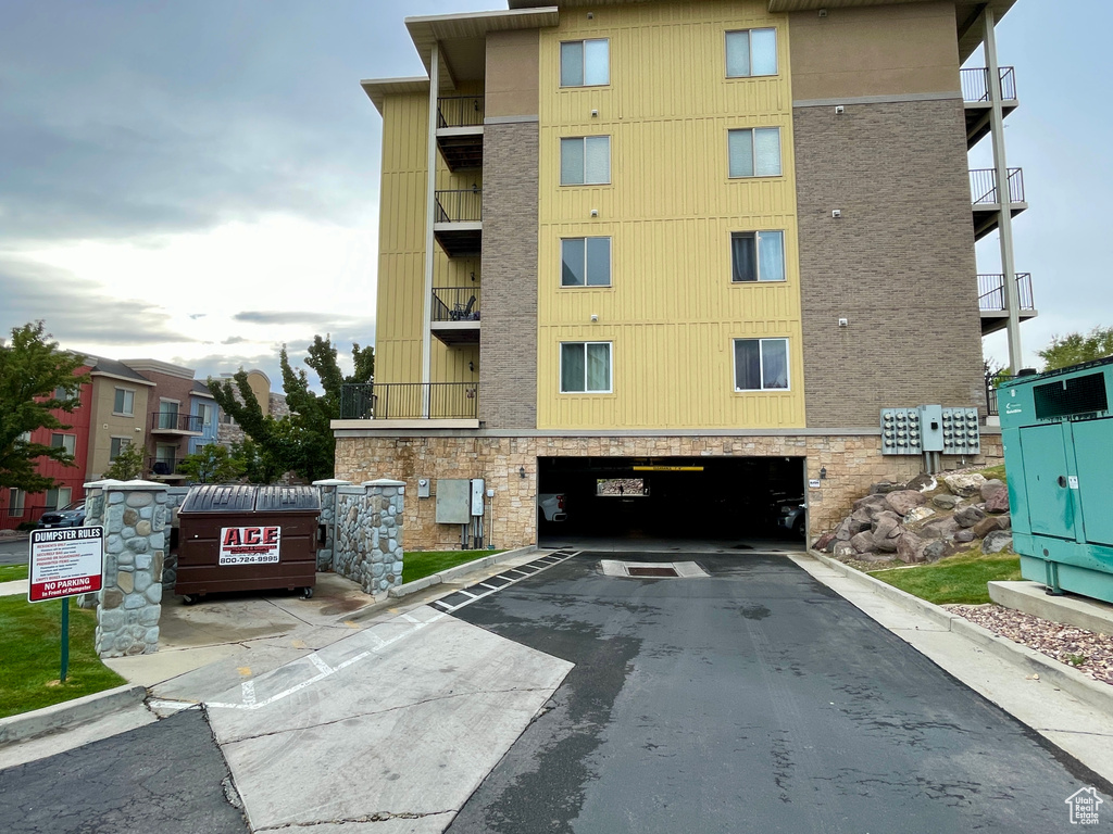 View of property with an attached garage and aphalt driveway
