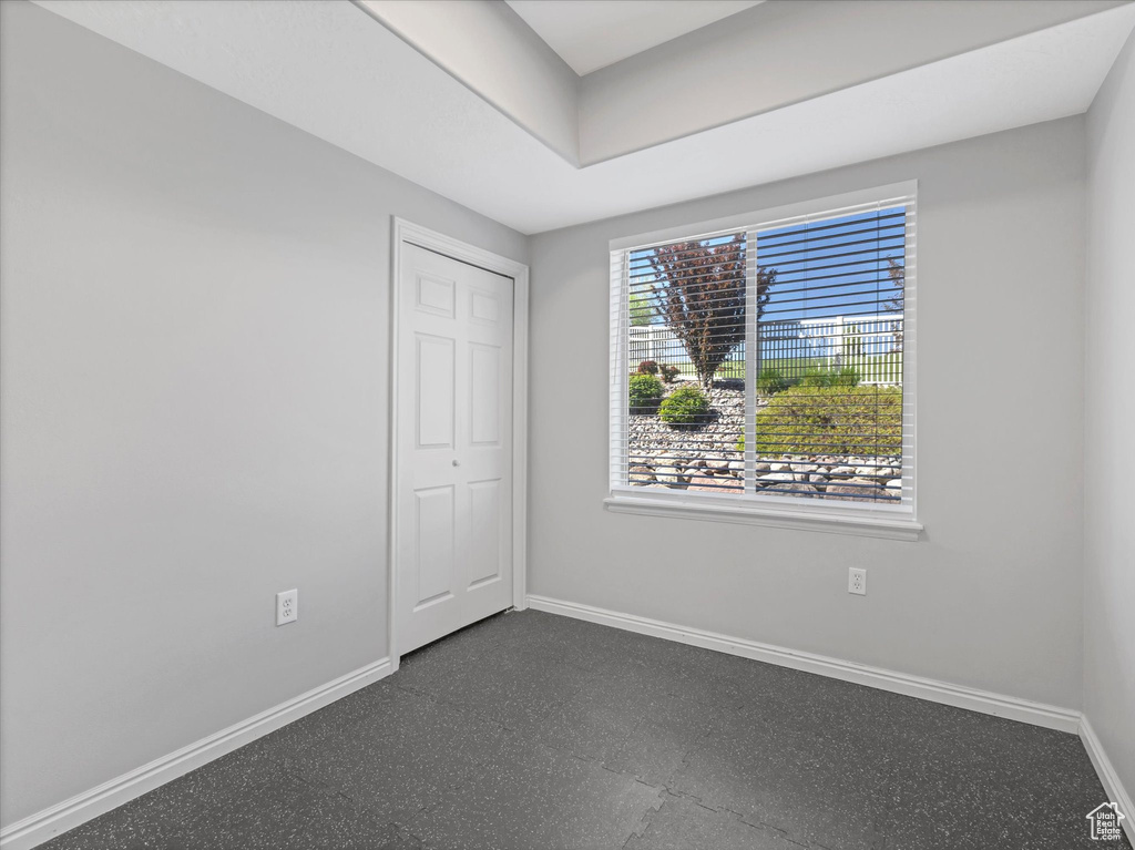Unfurnished bedroom featuring a closet, baseboards, and dark floors