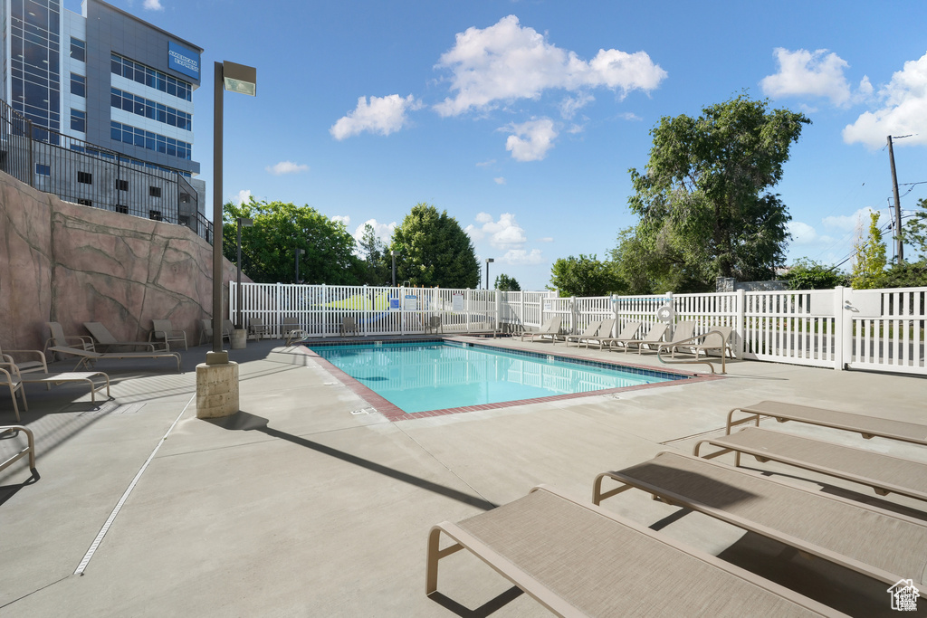 Community pool featuring a patio and fence