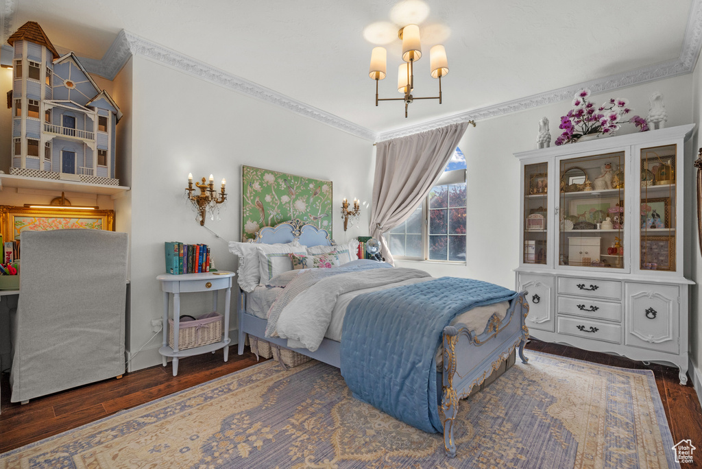 Bedroom featuring crown molding, a notable chandelier, and wood finished floors