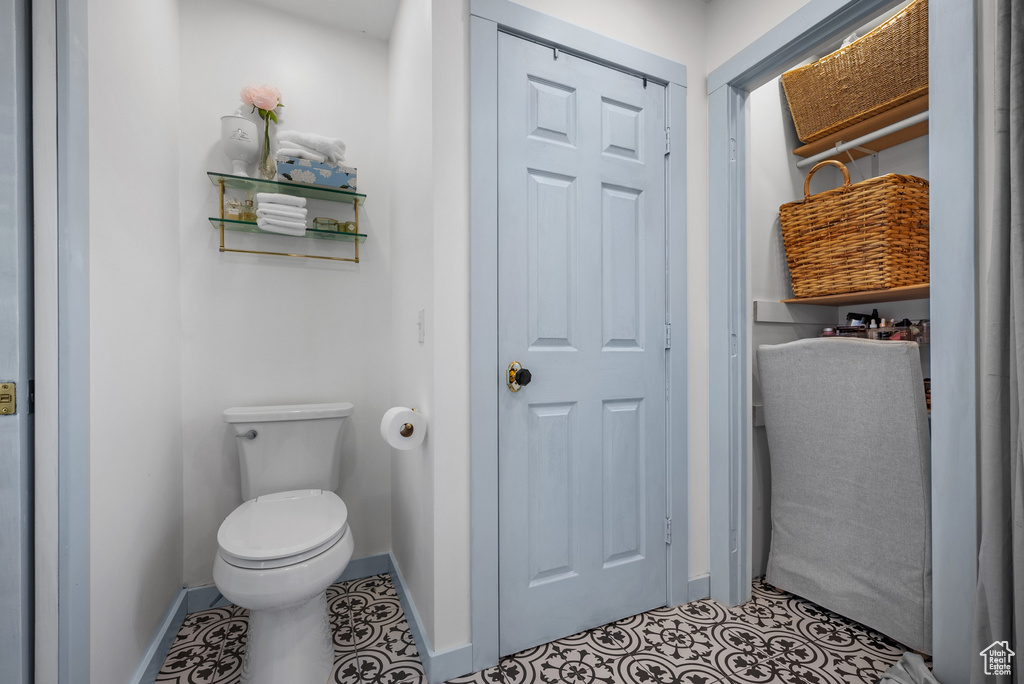 Bathroom with baseboards, tile patterned flooring, and toilet