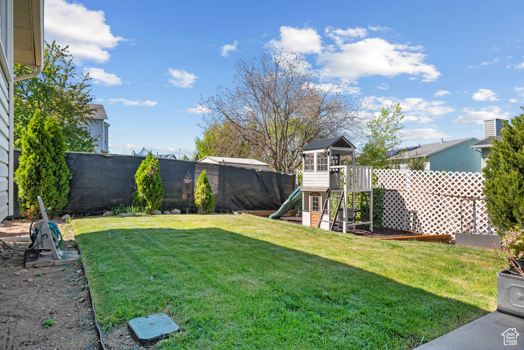View of yard with a fenced backyard and a playground