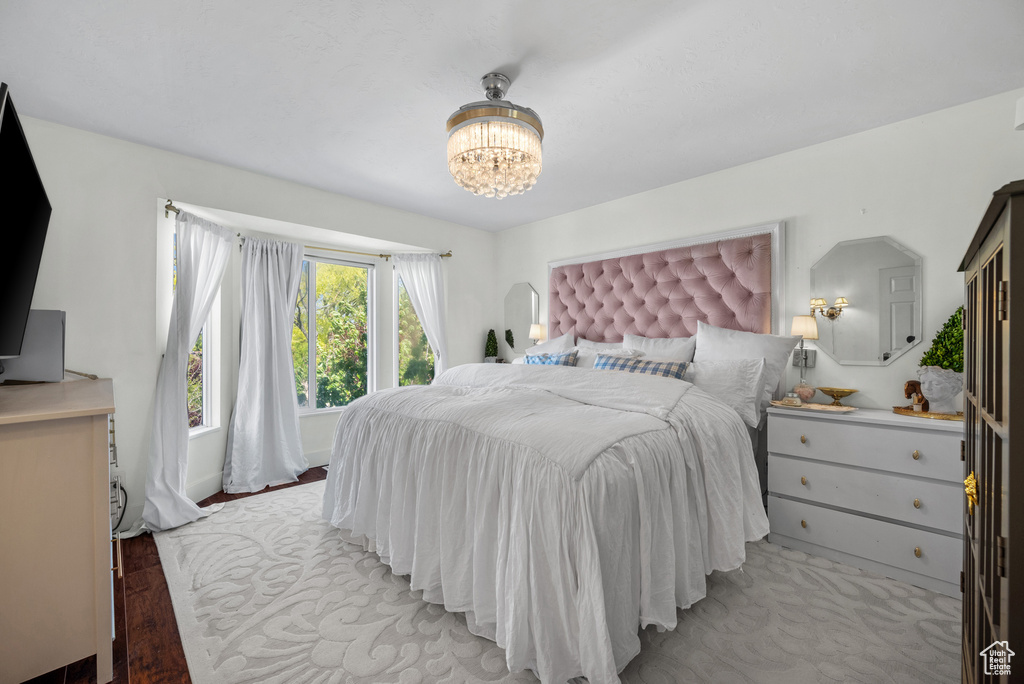 Bedroom featuring light wood-style floors and a notable chandelier