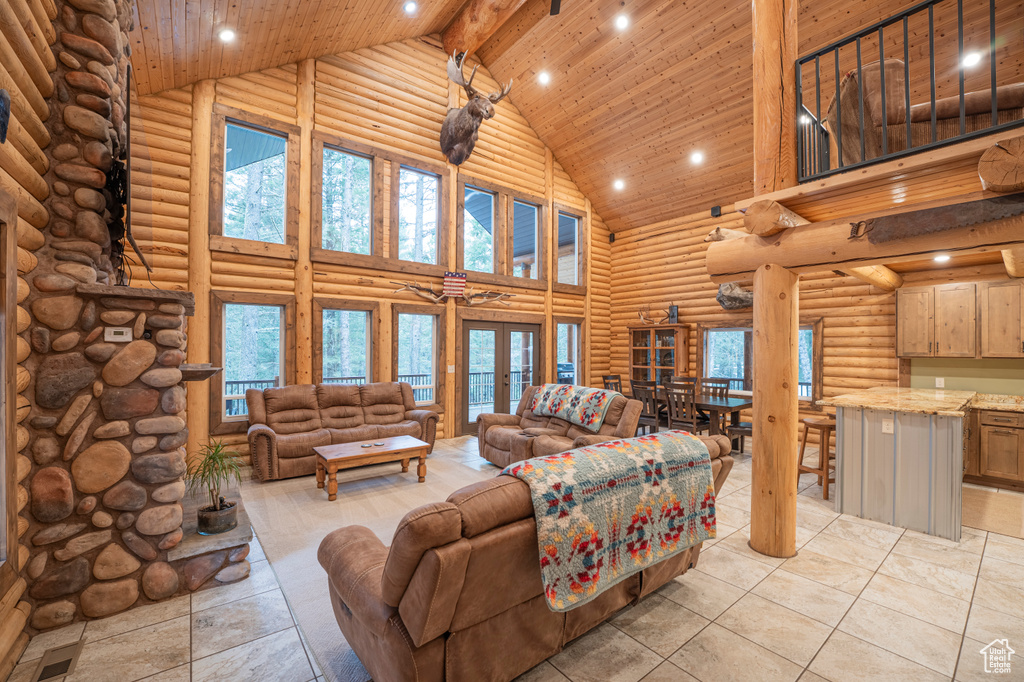 Living room featuring high vaulted ceiling, rustic walls, wood ceiling, and recessed lighting