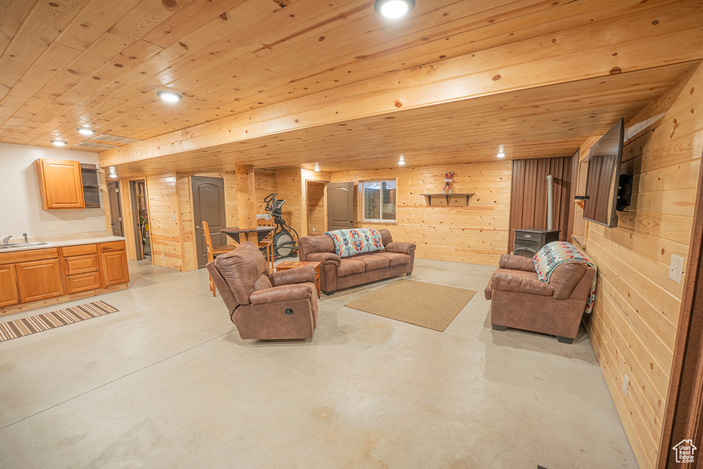 Living room with finished concrete flooring, wooden walls, and wood ceiling