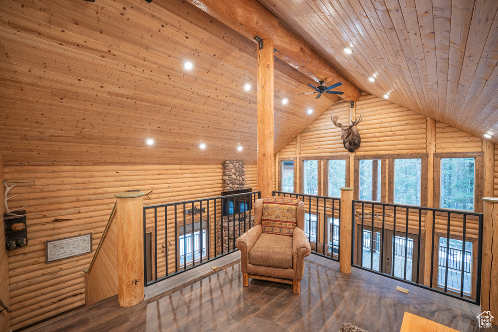 Sitting room with a ceiling fan, wooden ceiling, high vaulted ceiling, log walls, and a wealth of natural light