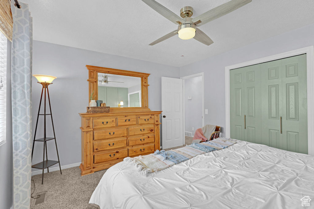 Bedroom featuring baseboards, carpet flooring, a ceiling fan, and a closet