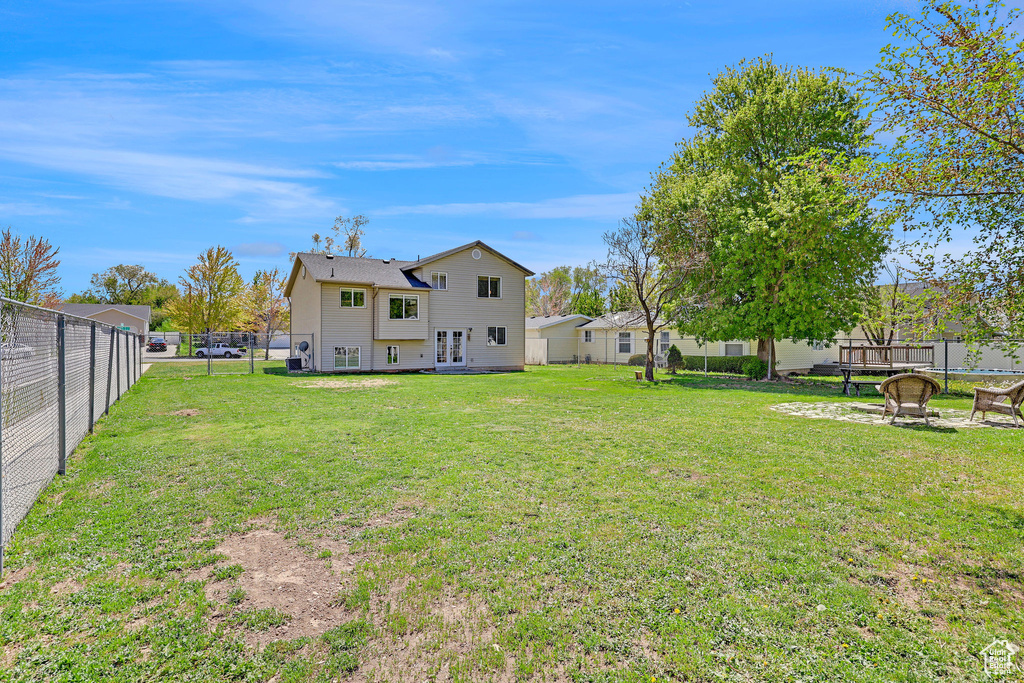 View of yard with a fenced backyard and french doors