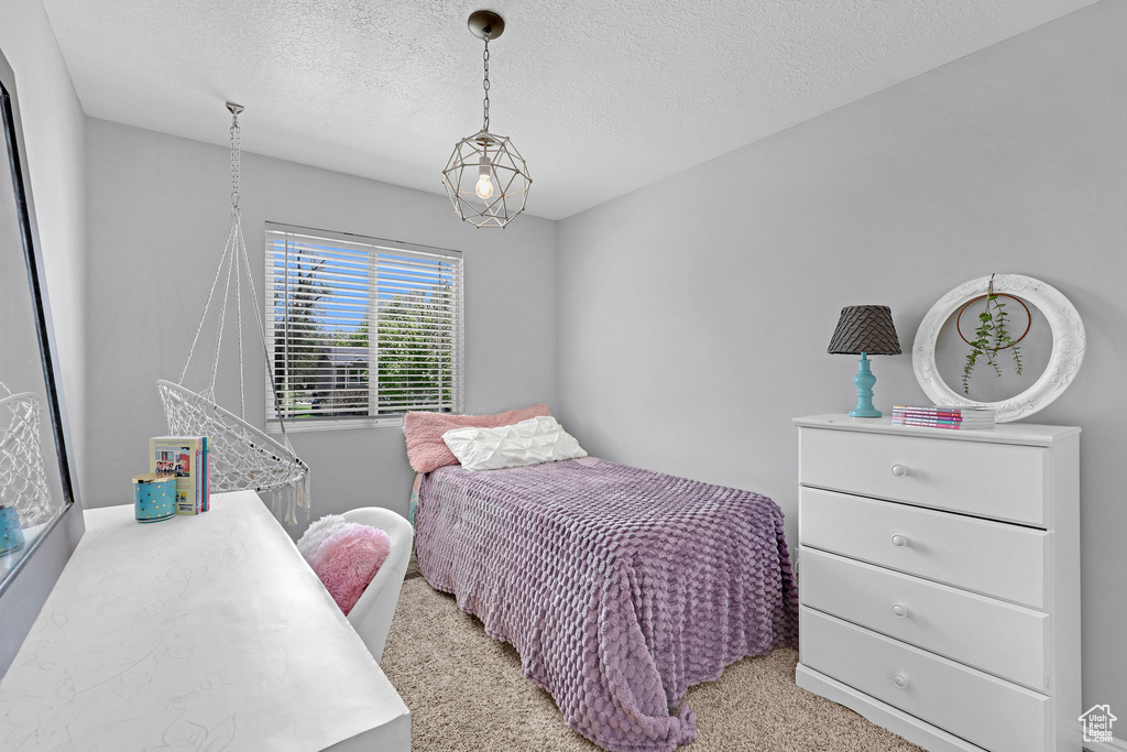 Bedroom with light carpet and a textured ceiling