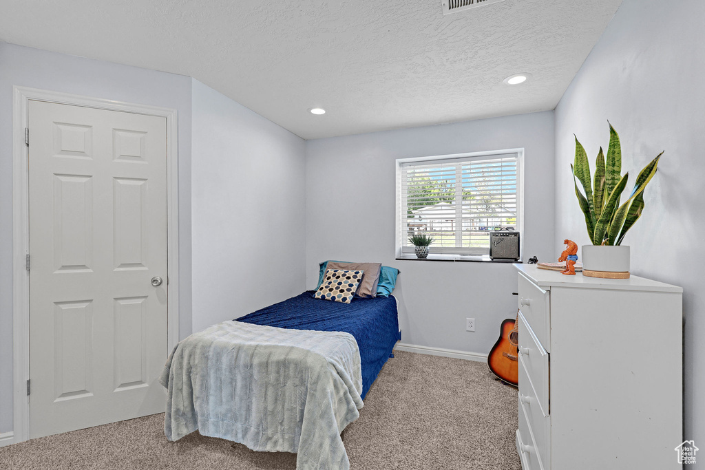 Carpeted bedroom with baseboards, recessed lighting, a textured ceiling, and visible vents