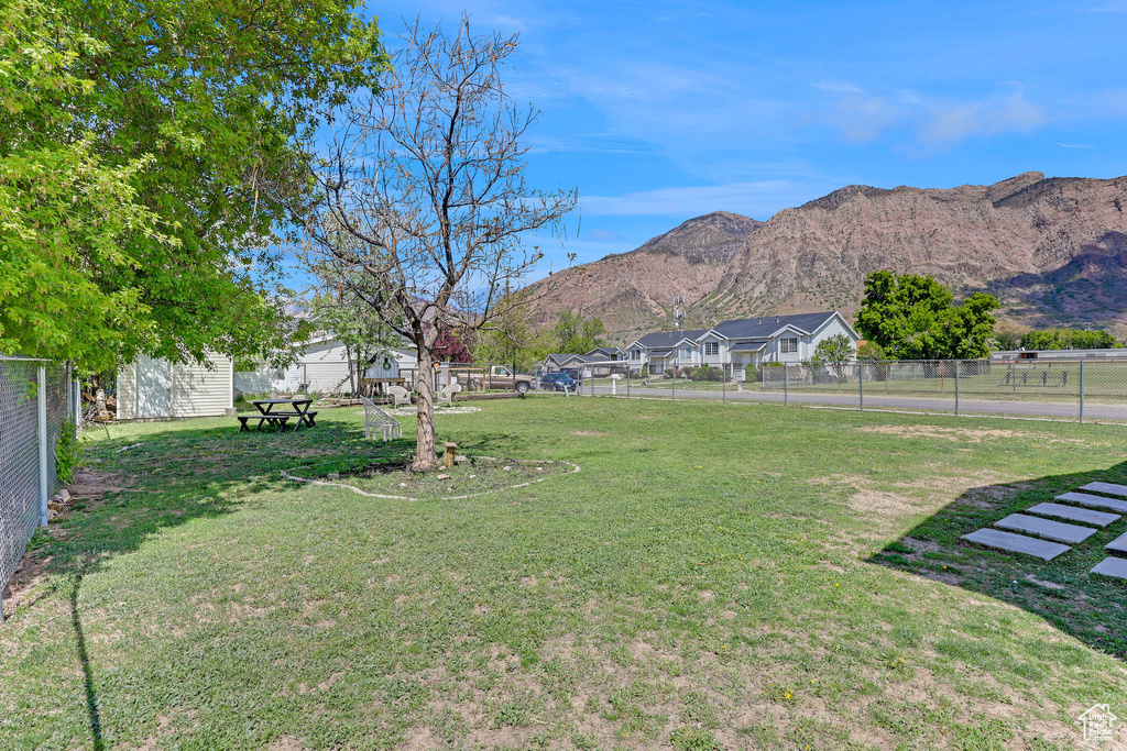 View of yard with a mountain view, fence, and a residential view