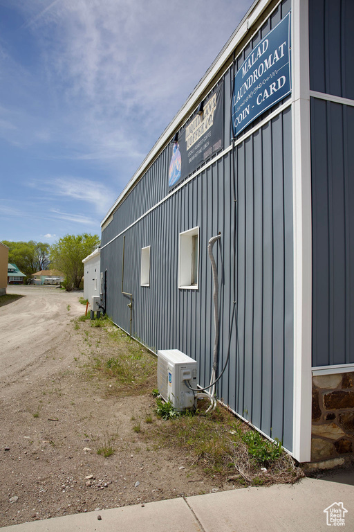View of side of home featuring board and batten siding and ac unit