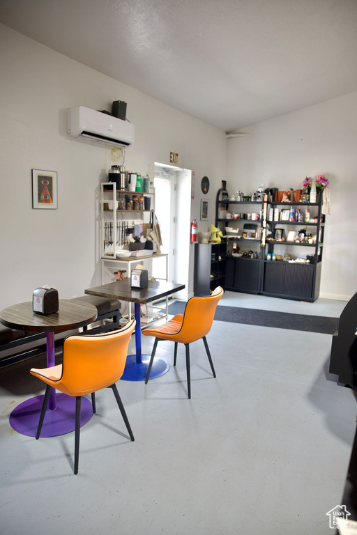 Dining area with a wall unit AC and finished concrete floors