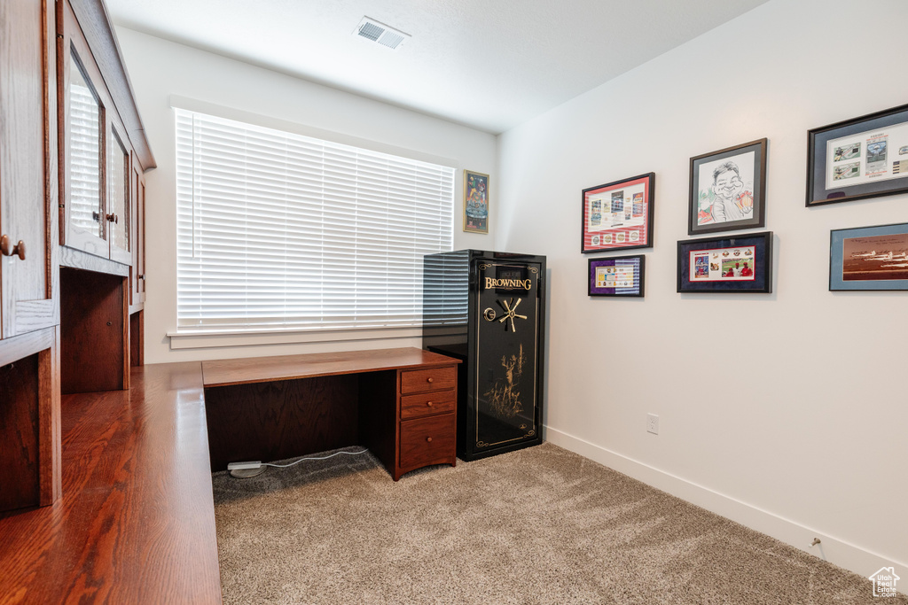 Carpeted home office featuring baseboards, visible vents, and a wealth of natural light