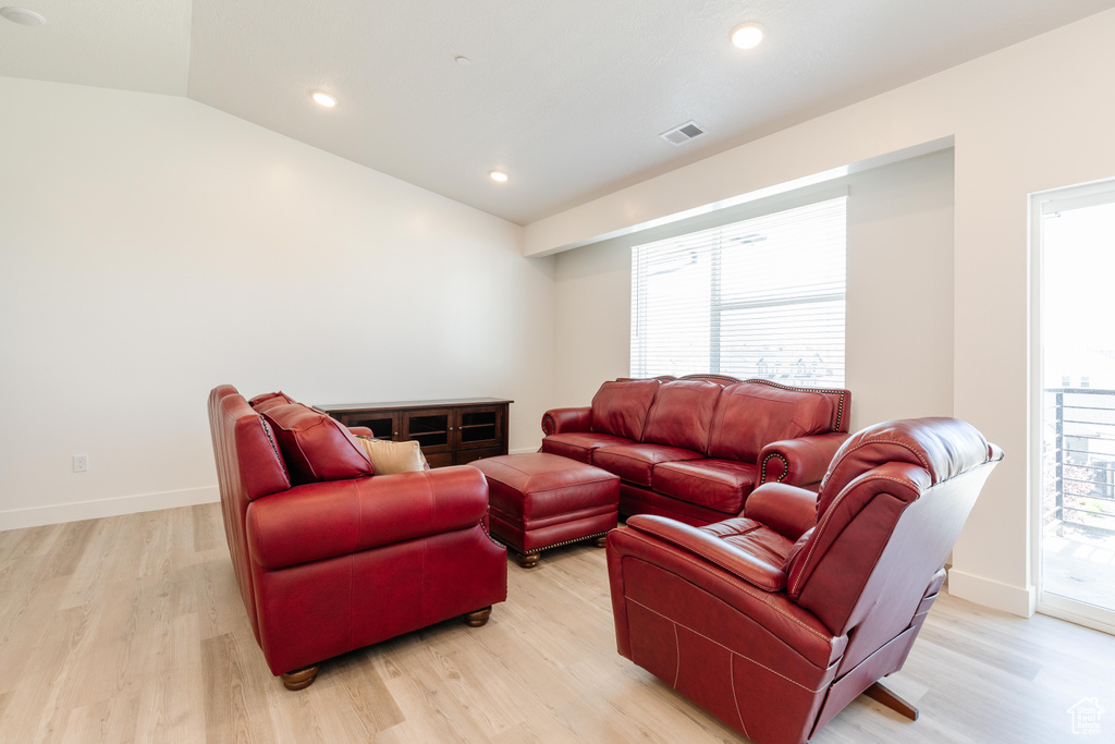 Living area featuring recessed lighting, visible vents, light wood-style flooring, and vaulted ceiling