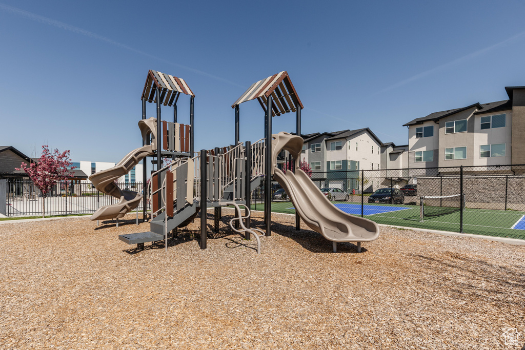 Community play area with fence and a residential view
