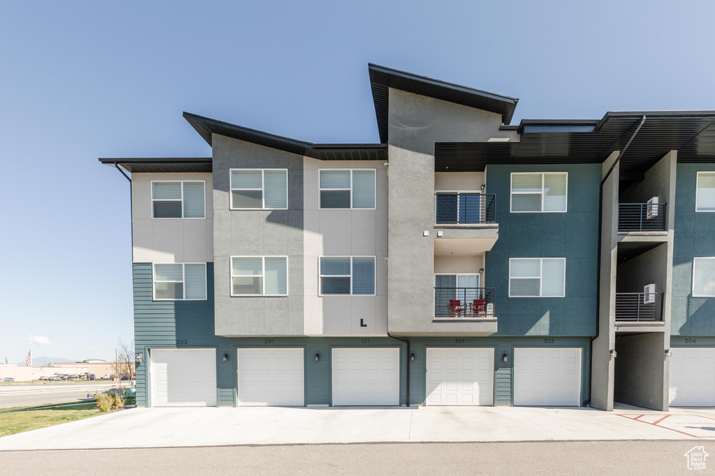 View of front of home with a garage, stucco siding, and driveway