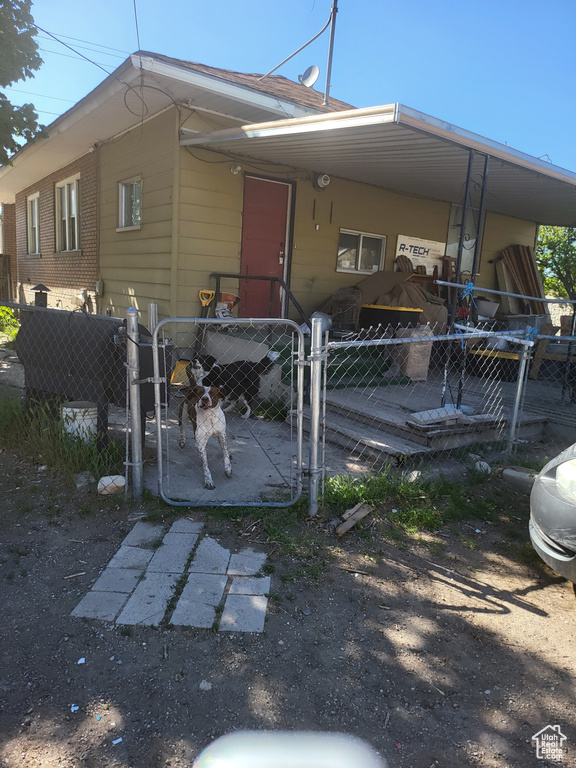 Back of property with fence private yard, a gate, and a carport