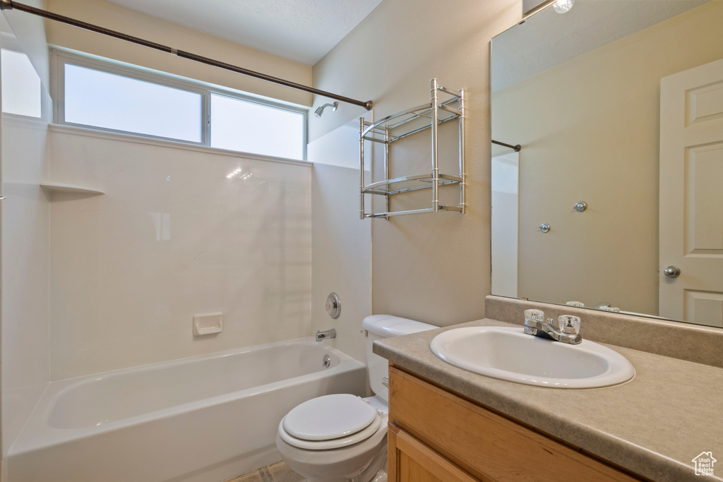 Bathroom featuring vanity, toilet, and  shower combination