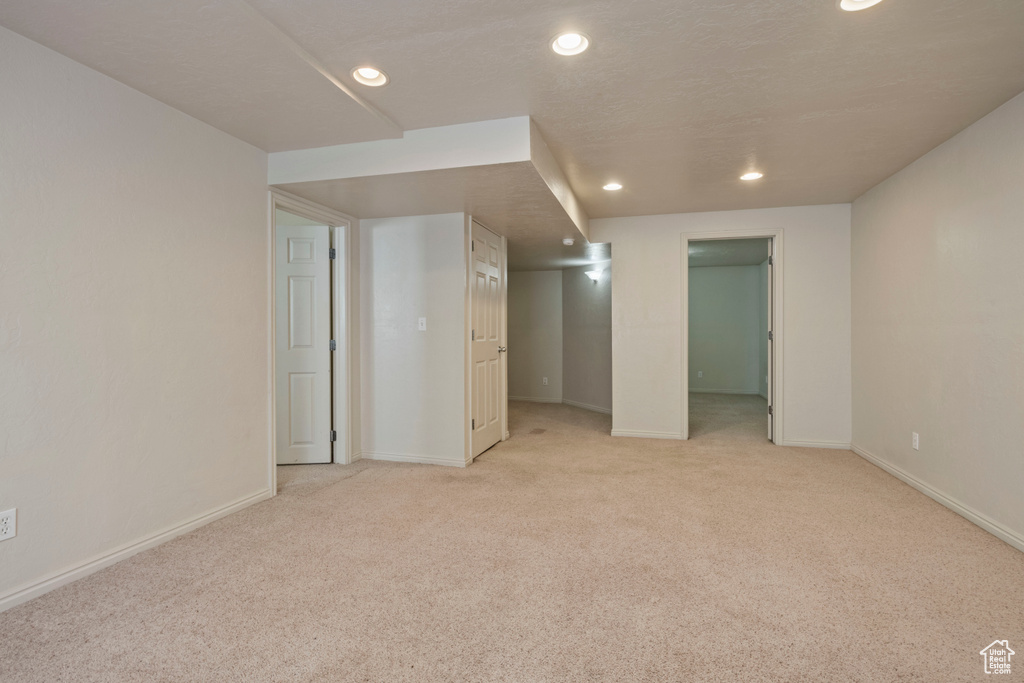 Empty room featuring recessed lighting, baseboards, and light carpet