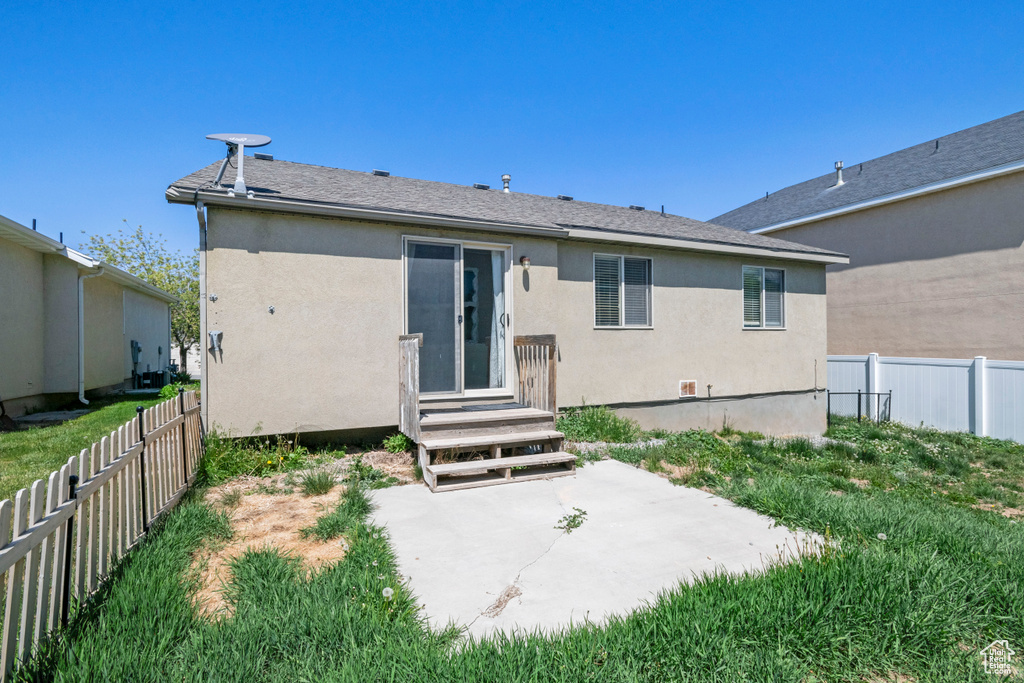 Back of property with a fenced backyard, a patio, and stucco siding