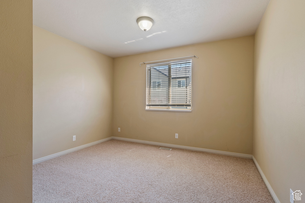 Spare room with carpet floors, baseboards, and visible vents