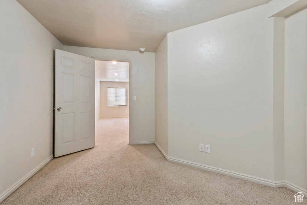 Empty room featuring baseboards and carpet flooring