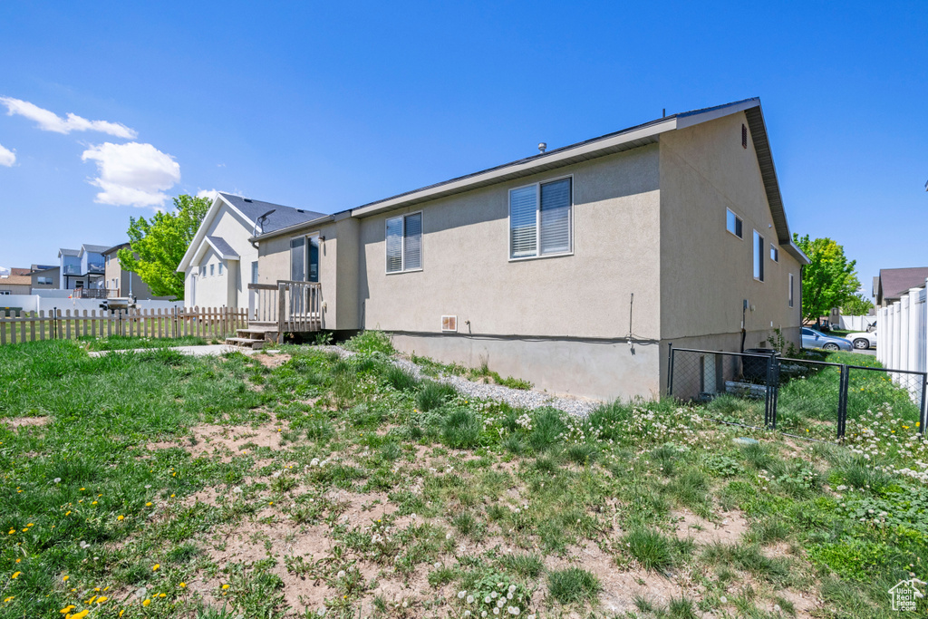 Back of property featuring stucco siding and fence
