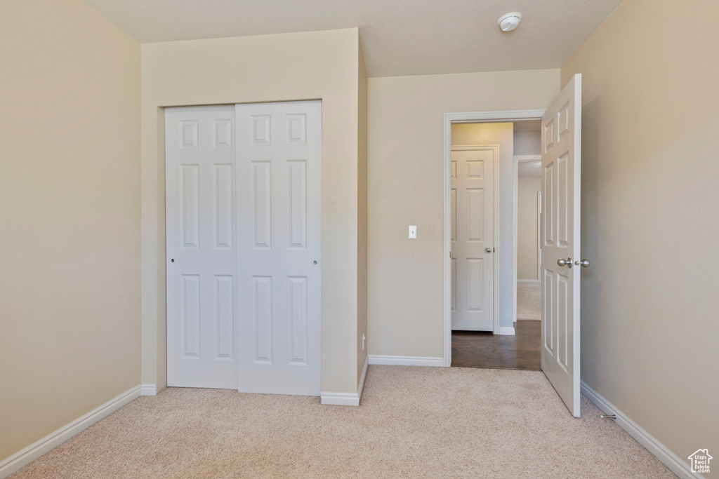 Unfurnished bedroom featuring baseboards, carpet, and a closet