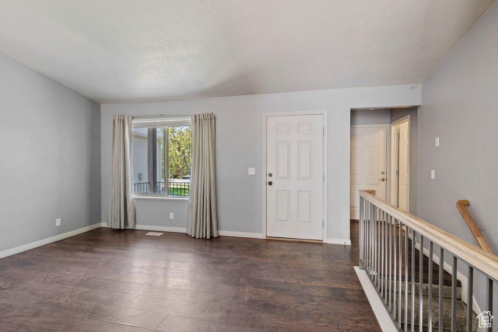 Foyer with baseboards and wood finished floors