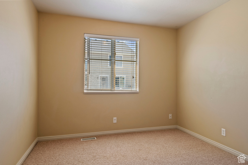 Carpeted spare room with baseboards and visible vents