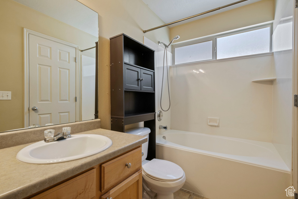 Bathroom featuring shower / bath combination, vanity, and toilet
