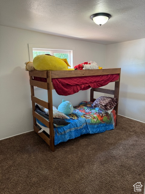 Carpeted bedroom featuring a textured ceiling