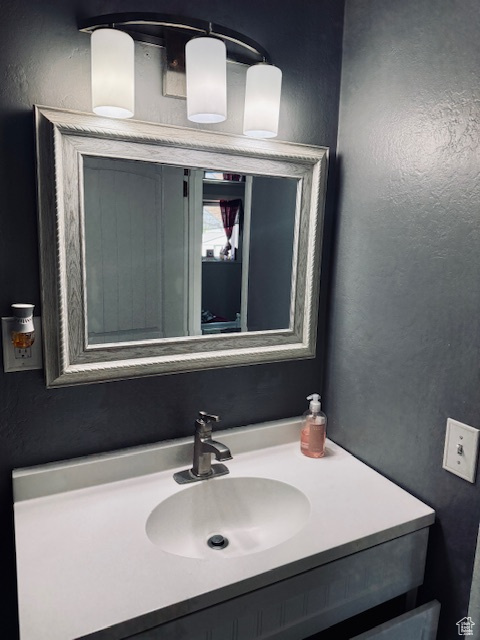 Bathroom featuring a textured wall and vanity
